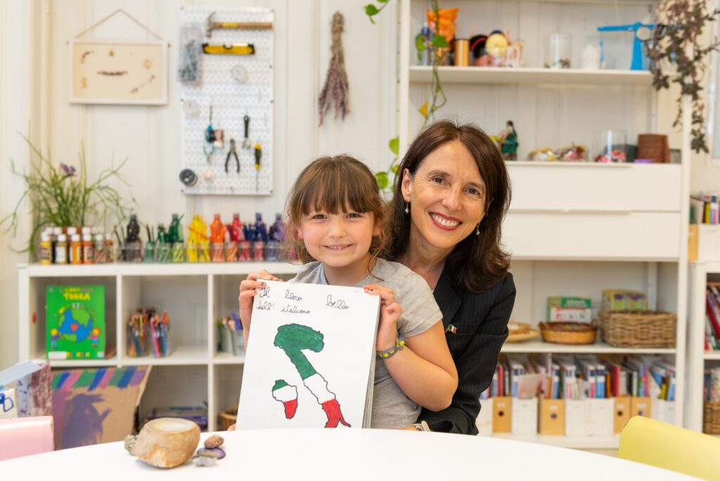 A student and her teacher holding up a drawing in the atelier